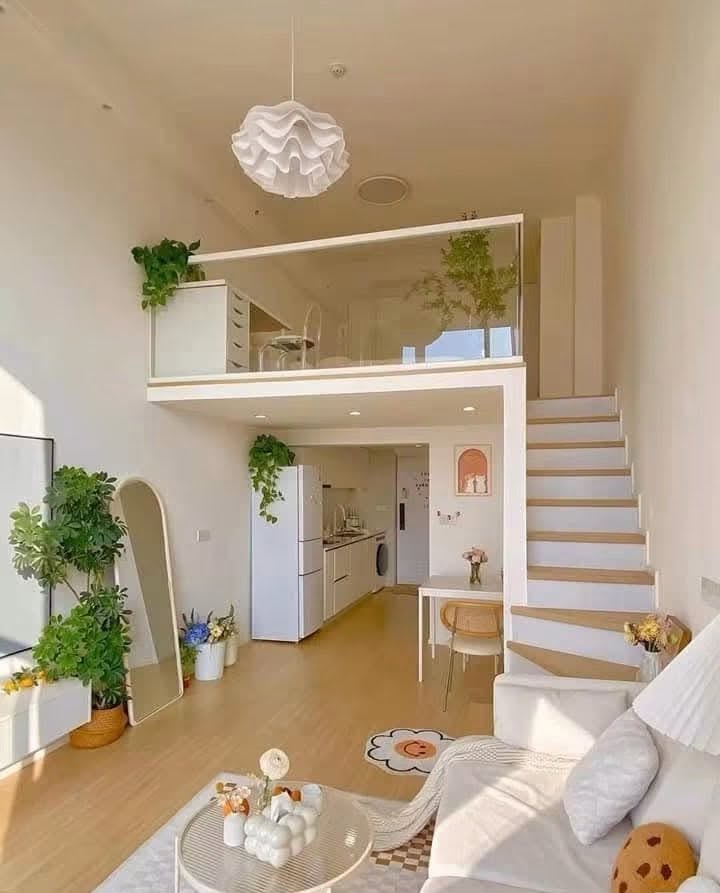 The same unit finished: a bright loft with a glass-railed mezzanine, timber stairs, fitted kitchen and living area