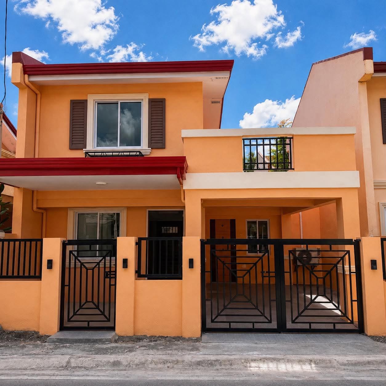 A completed peach two-storey duplex with red roof trim and patterned steel gates